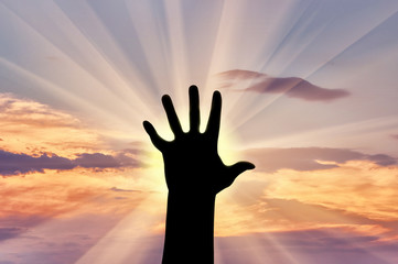 Silhouette hand covers the sun