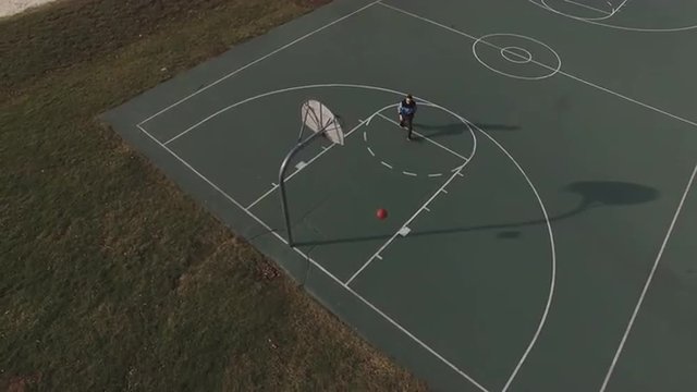 Boy shooting ball at hoop trying to get practice for the sport.