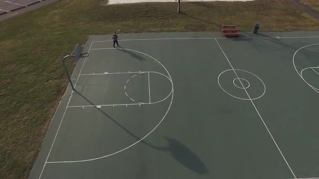 Boy shooting shots at hoop to get some practice in for next season.