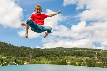 Young boy jumping on bouncing pillow