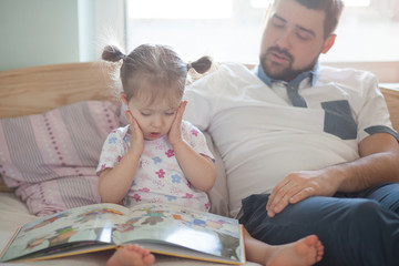 Obraz premium Emotional toddler girl reading a fairy tail