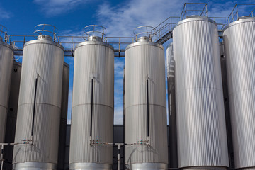 Giant industrial tanks on the bright blue sky