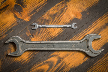 Big and small. Two wrenches on wooden background.