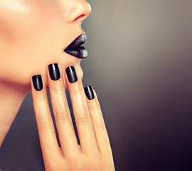 Beautiful girl showing black  French  manicure nails . makeup and cosmetics
