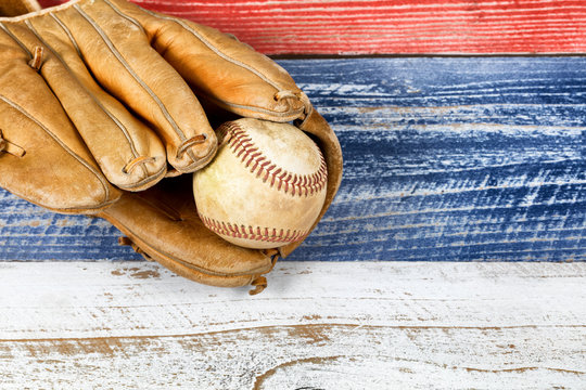 worn baseball mitt and ball on faded boards painted in USA colors - Powered by Adobe