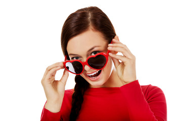 Happy brunette woman with sunglasses in the shape of hearts