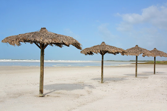 Row Of Grass Beach Cabanas By The Ocean