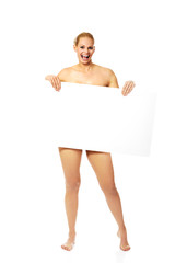 Sexy naked blonde holding empty board
