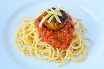 Lentil meatball with burst tomato pasta served on white plate