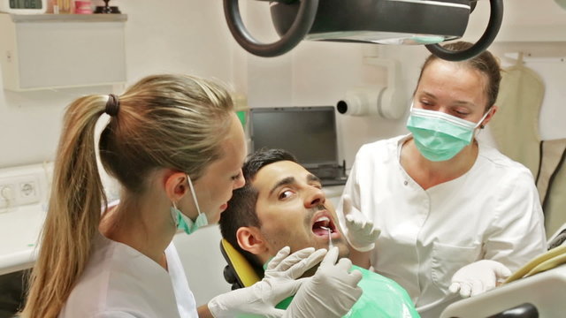 Portrait of doctor and frightened patient at dental clinic
