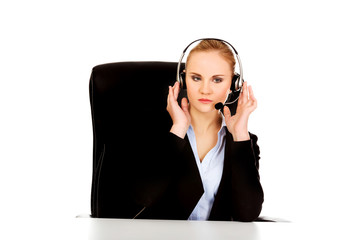 Phone operator in headphones sitting behind the desk