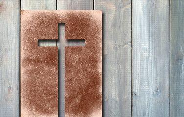 Old vintage Christian paper cross on wood background