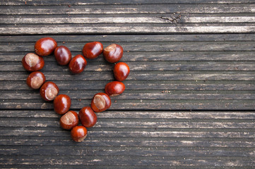 heart from chestnuts on a wooden terrace