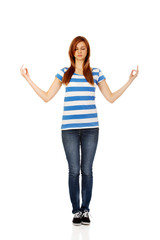 Obraz premium Teenage woman makes meditating gesture