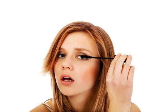 Teenage beautiful woman applying mascara