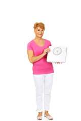 Smiling old woman holding weight scale