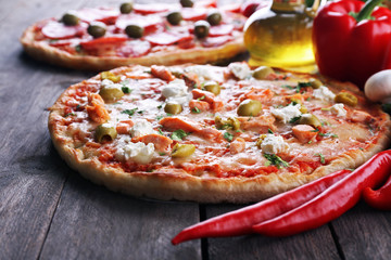 Delicious tasty pizzas with ingredients on table, closeup
