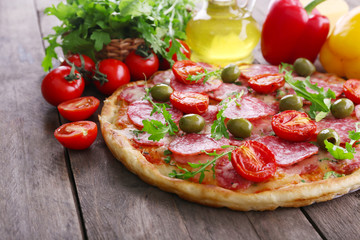 Delicious tasty pizza with ingredients on table, closeup