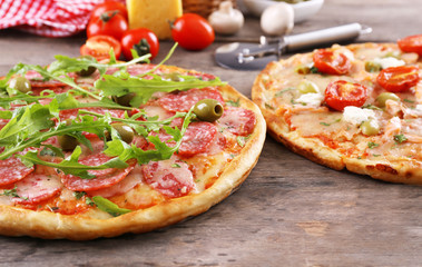 Delicious tasty pizzas with ingredients on table, closeup