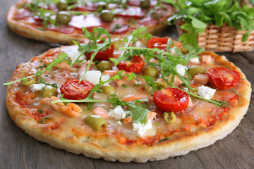 Delicious tasty pizzas with ingredients on table, closeup