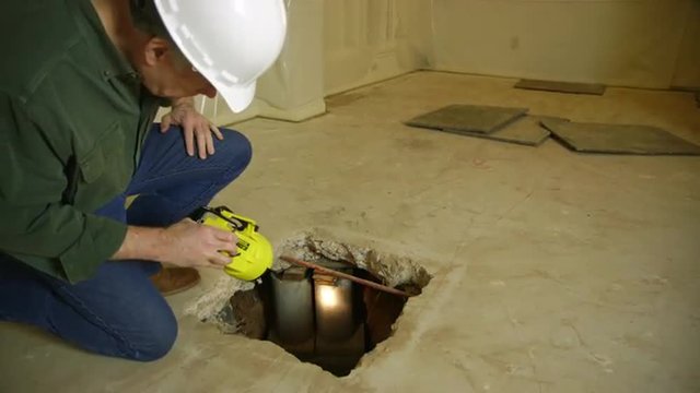 An inspector or engineer checking interior repairs made to the foundation of a house.