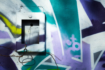 Un mur peint avec un graffiti de couleur verte, blanc, bleu, jaune