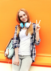 Happy pretty smiling girl with headphones listens to music havin