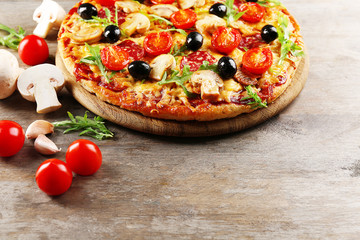 Delicious tasty pizza with ingredients on wooden table