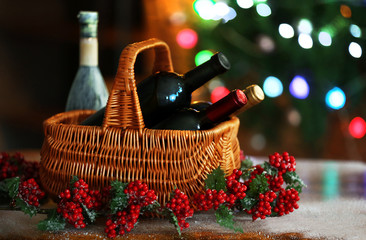 Wine in basket on blurred Christmas tree background