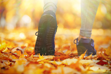 Close-up running feet in autumn park