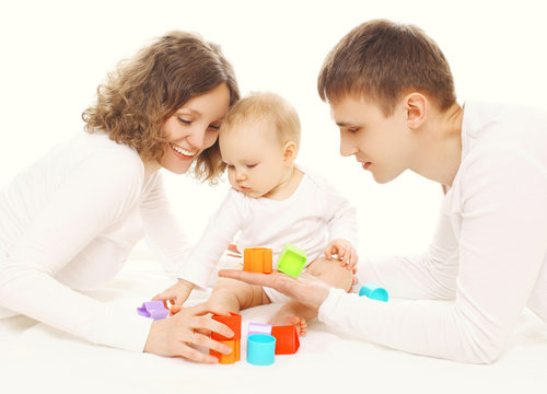 Family together, parents and baby playing with colorful toys