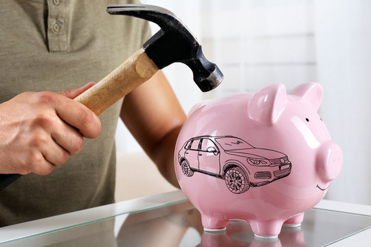 Man with a hammer going to break the piggy bank, close up