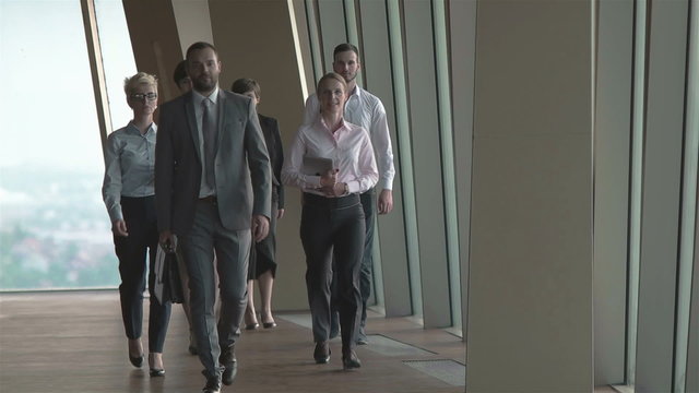 business team, businesspeople  group walking at modern bright office interior