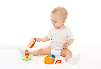 Cute baby playing with toys on white background
