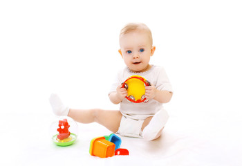 Cute little baby playing with toys on white background