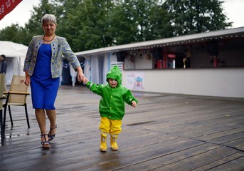 Happy little boy in not getting wet clothes together with grandmother