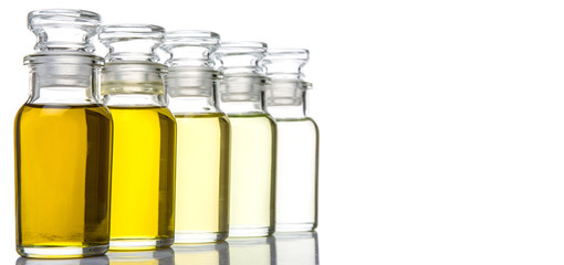 Avocado fruit oil, sesame seed oil, olive oil, grape seed oil and corn oil in vial glass bottle over white background