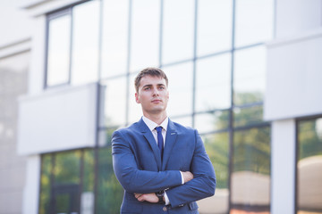 Portrait of a young businessman standing over blurred background 