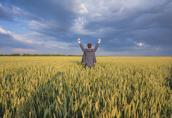 Happy businessman standing on the field 