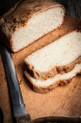 Wooden cutting board sliced white bread and knife 