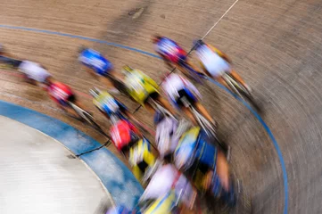 Wall murals Bicycles Indiscernible pack of track cyclists racing past on the turn of a velodrome