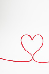 Red heart string on white background 
