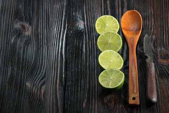 Cut limes with rusty german knife on old wooden table