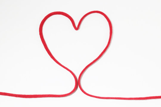 Red heart string on white background 
