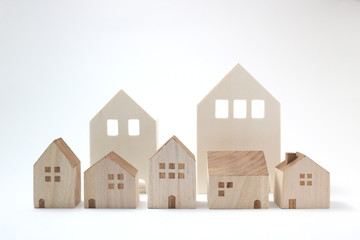 Miniature houses on white background. Building blocks arranged in row.