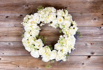 White flowers forming wreath on rustic wooden planks