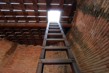 exit of a dark room, wood ladder from basement 