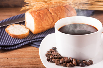 A coffee and bread with a soften light of morning background is texture of gain and wooden table, coffee concept