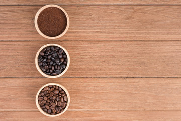 Coffee powder and coffee beans in the wood bowl on the wooden table