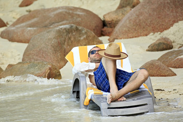 Tourist resting on a lounger. Sandy beach at the shores of India